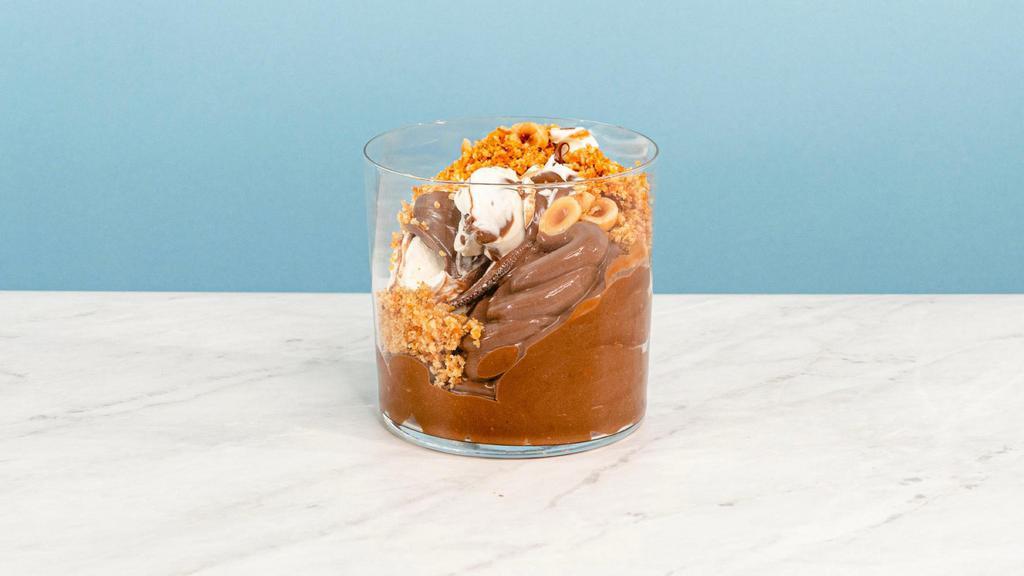 Praline Chocolate Pud · This decadent hazelnut-praline pudding combines rich chocolate pudding with a layer of hazelnut-praline whipped cream, roasted hazelnut crunch and a whisper of flaky salt and nutmeg | Allergen: Milk, Egg, Tree Nuts