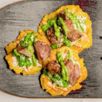 Tostones Meat · Tostones with steak, chicken or chorizo, cheese cabbage, and sauces.