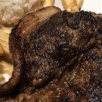 Bisteck A Lo Pobre · Grilled steak with fried egg rice French fries and sweet plantains
