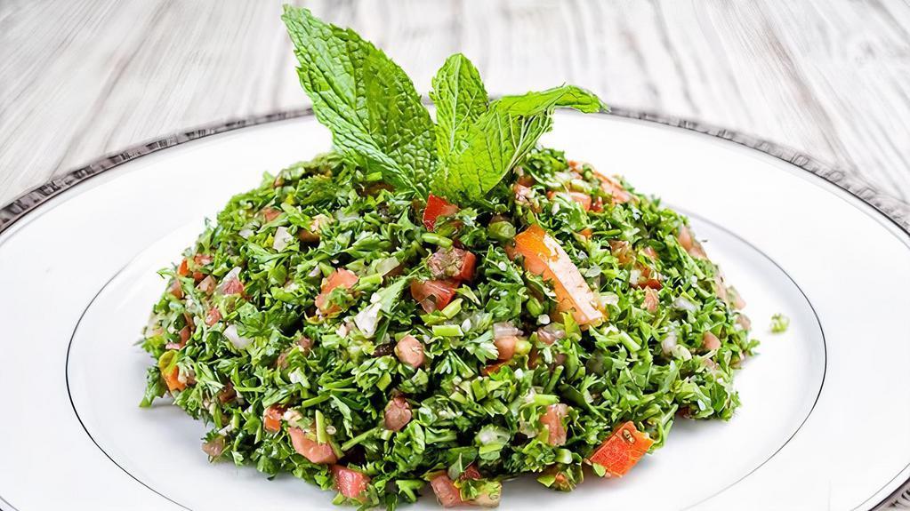 Tabbouleh · A fresh parsley salad with cracked wheat, scallion, and tomato. Seasoned with olive oil, lemon juice dressing.
