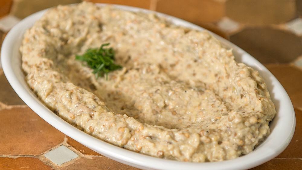 Baba Ghanoush · Smoked eggplant flavored with tahini, garlic, black pepper, lemon juice, and olive oil.