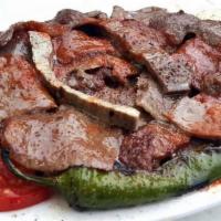 Iskender Kebab · Doner kebab served over sautéed homemade bread, topped with fresh tomato sauce and served wi...