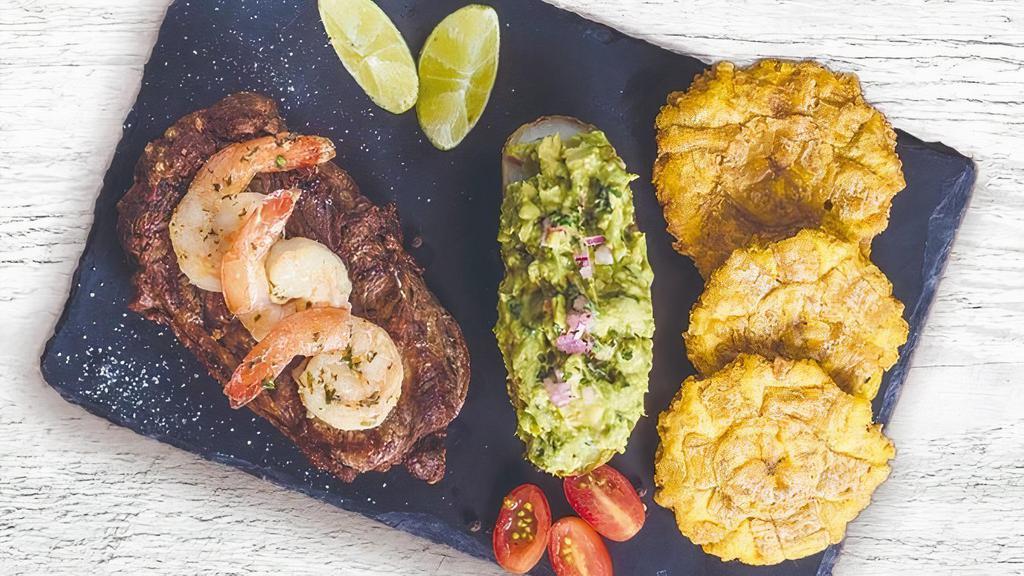 Ny Steak & Garlic Shrimp · Grilled juicy NY steak with garlic shrimp on top, steamed potato with guac and tostones.