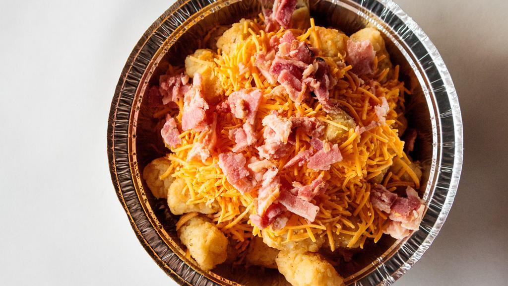 Large Cheesy Bacon Tots · Crispy, golden tots topped with cheddar cheese and bacon. Served with ketchup on the side.