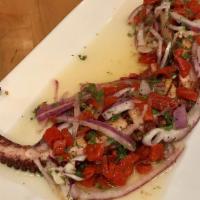 Pulpo A La Parilla · Grilled Octopus with chopped red onion and dried roasted peppers. In a red wine vinaigrette