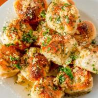Garlic Knots · A classic snack, our garlic knots
are strips of pizza dough tied in a
knot, baked, and then ...