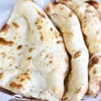 Naan · The traditional leavened bread from the clay oven.