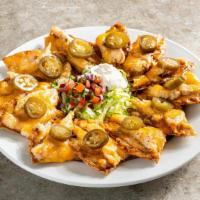 Classic Nachos With Chicken · Chicken, shredded cheese, black beans, jalapeños, Skillet Queso with beef. Served with pico ...