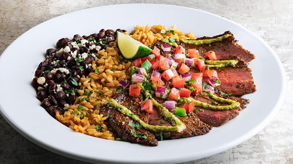 Cilantro-Lime Carne Asada · Seared steak, topped with a drizzle of cilantro-pesto, lime and pico de gallo. Served with Mexican rice & black beans.