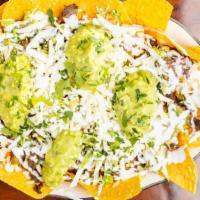 Nachos Texanos · Chips with beans, guacamole, cheese, onions, cilantro and sour cream with choice of meat.