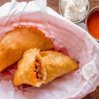 Pastelitos · Empanadas. Fried corn mix casing stuffed with ground beef, potatoes, carrots and rice. Serve...