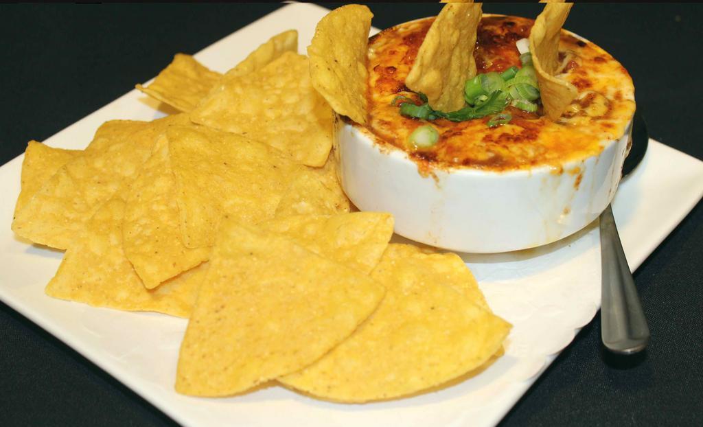 Homemade Beef Chili · Gluten-free. Housemade beef chili with onions, tomatoes, and spicy seasoning. Topped with Cheddar-Jack cheese and served with tortilla chips.