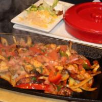 Sizzling Fajitas · Marinated steak or all-natural free-range chicken, spiced vegetables, lettuce, cheese, sour ...