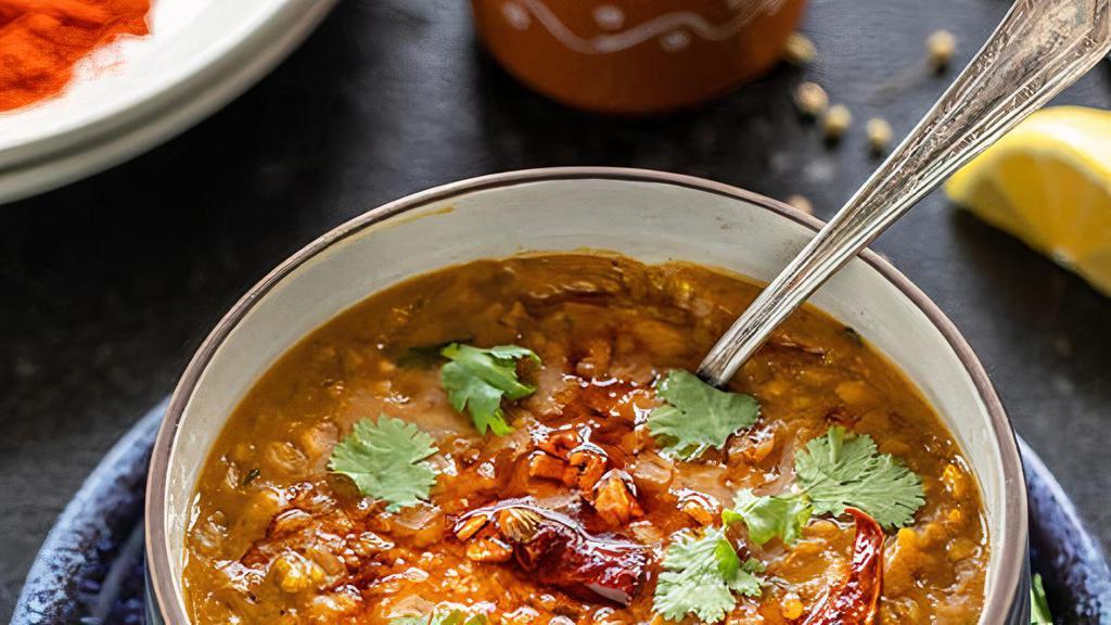 Daal Tadka  · Yellow lentils cooked with onion, tomato, and sauteed cumin seeds.