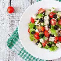 Greek Salad · Crisp lettuce, feta cheese, stuffed grape leave, tomato, olives, and onions.