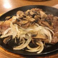 Sizzling Rib Steak · With mushroom and onion.