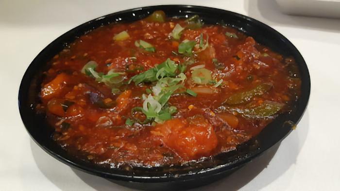 Chicken Kadhai · Savory chicken cooked in a kadhai with onions, tomatoes, ginger, garlic and bell peppers.