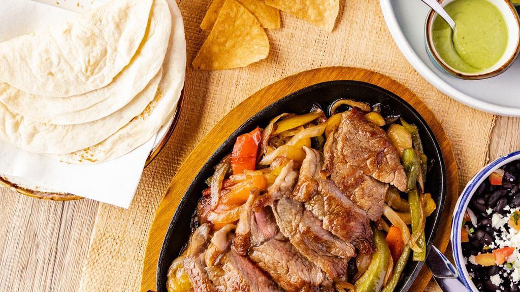 Fajitas Steak · Build your own taco with grilled onions, peppers, guacamole, salsa roja, pico de gallo, sesame seed  oro negro sauce, warm flour tortillas, side of rice & beans