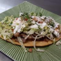 Beef Huaraches · Bistec. Served with reried beans, lettuce, cream, avocado, pico de gallo and queso molido.
