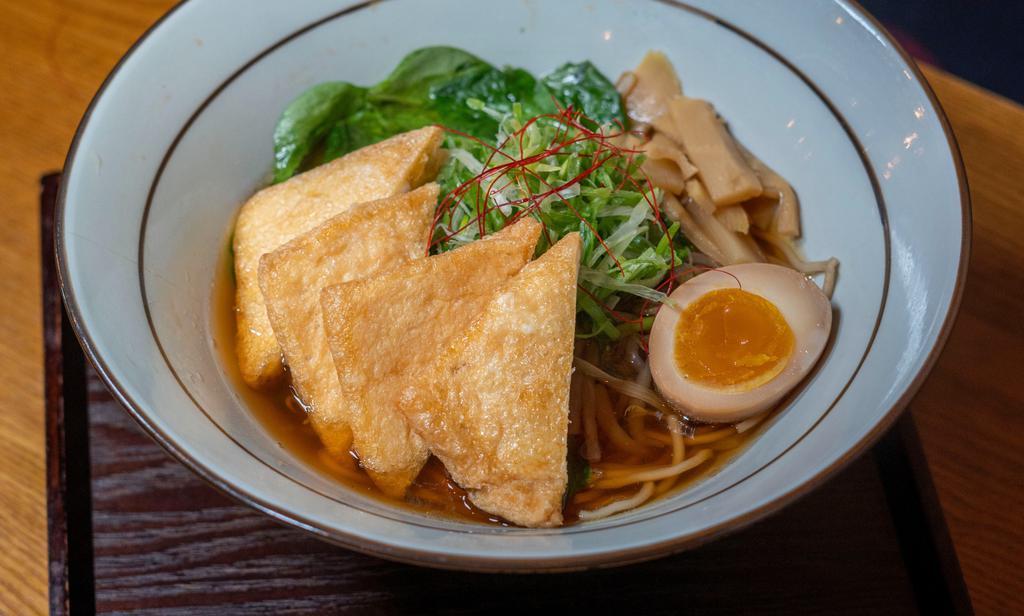 Veggie Shoyu Ramen · Rich soy based soup in noodles. Topped with bean sprouts, scallions, spinach, fried tofu, bamboo shoots, and marinated egg.