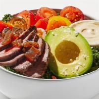 Steak Kale Caesar Salad · Cashew Kale Caesar, farm greens with mint, sliced peppercorn steak with grilled onion, avoca...