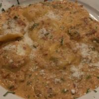 Lobster Ravioli · Homemade lobster ravioli in a prosciutto and scallion pink cream sauce.