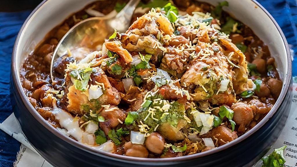 Samosa Chaat · Vegetable Samosas topped with a combination of chickpeas, yogurt, mint sauce and tamarind sauce