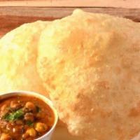 Chole Bhature · Puffed pooris served with chickpeas curry