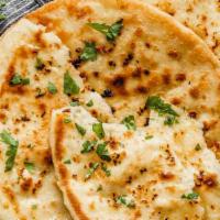 Garlic Naan · Soft flour bread mixed with minced garlic and baked in a tandoori oven and then coated with ...