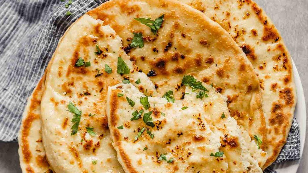 Garlic Naan · Soft flour bread mixed with minced garlic and baked in a tandoori oven and then coated with melted butter
