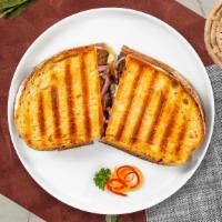 Pastrami Reuben Panini · Grilled pastrami, your choice of cheese, coleslaw, and russian dressing served on a flat pan...