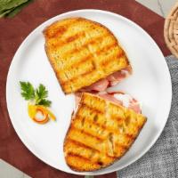 Turkey Club Panini · Turkey, bacon, Swiss cheese, lettuce, and tomato served on a flat panini bread.