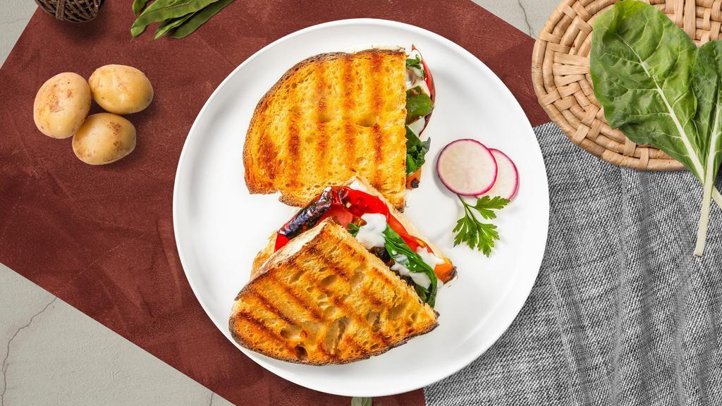 Vegetarian Panini · Grilled mushrooms, eggplant, sundried tomatoes, roasted peppers, onions, spinach, and mozzarella cheese served on a flat panini bread.