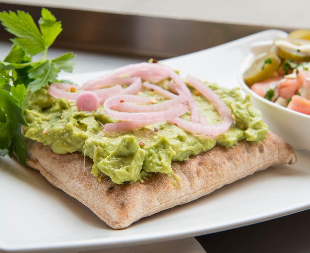 Mashed Avocado Pita Toast · Mashed Avocado on a toasted square pita topped with pickled onions and red pepper flakes.  Comes with one choice from the Maoz salad bar.