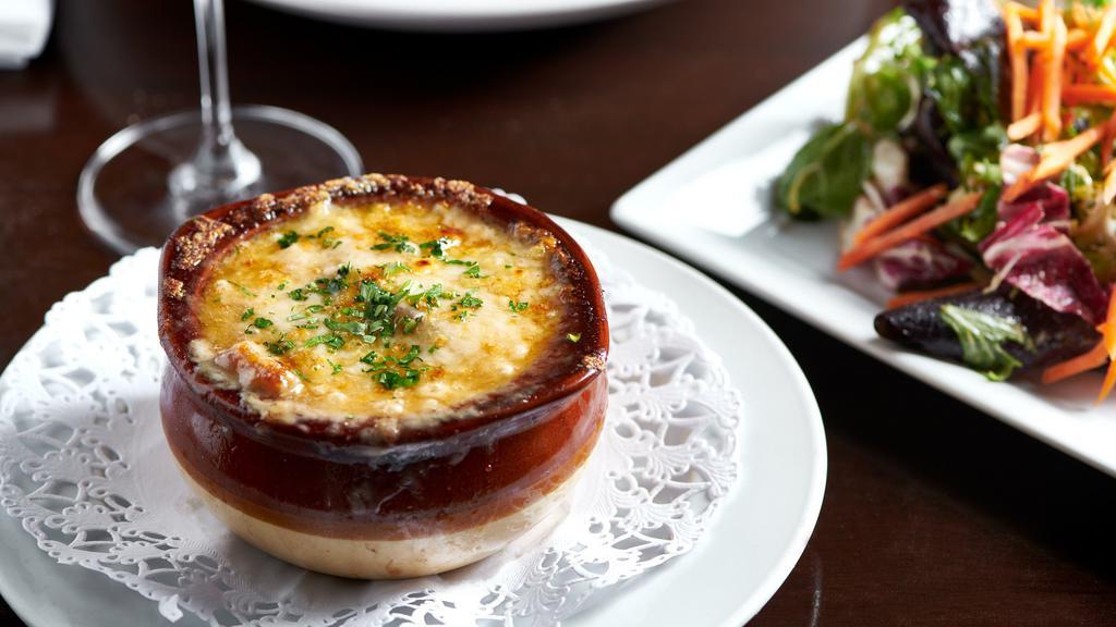 Onion Soup · Traditional French onion soup served with croutons, topped with Swiss cheese and Gratinée in a crock