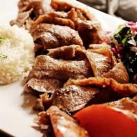 Homemade Gyro · Homemade lamb gyro cooked on a rotating spit and thinly sliced, with rice and salad.