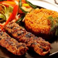 Chicken Adana · Ground chicken flavored with peppers, parsley paprika, and grilled on skewers, served with r...