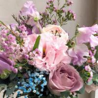 Olivia · A cool toned arrangement featuring seasonal purple, blue, pink florals and greens in a clear...