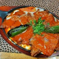 Iskender Kebab · Döner prepared from thinly cut grilled lamb topped with hot tomato sauce over pieces of pita...