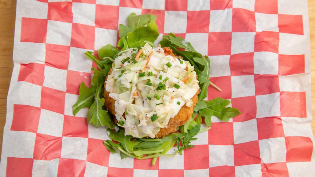Crab Cake · Jumbo lump crab cake fried and topped off with a drizzle of lemon aioli and a scoop of our homemade coleslaw on a bed of mixed greens.