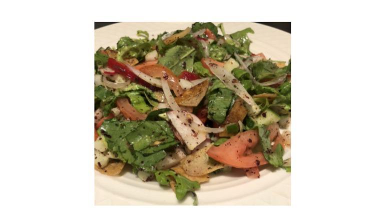Fattoush Salad · Number two salad in the middle East. Tomato, cucumbers, radish, onions, fresh mint, lettuce, parsley, red pepper and pita chips tossed in sumac, olive oil and lemon juice dressing.