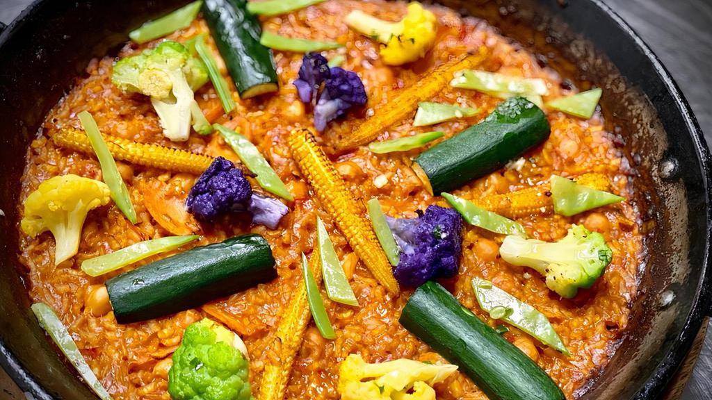 Paella De Vegetales · Gluten free. Classic Spanish bomba rice, sofrito, saffron, baby zucchini, eggplant, baby carrots, chickpeas, snow peas, baby corn.
