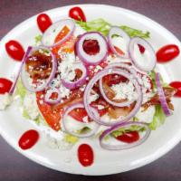 Iceberg Wedge Salad · With blue crumbles, blue cheese dressing, tomato, onion and bacon.