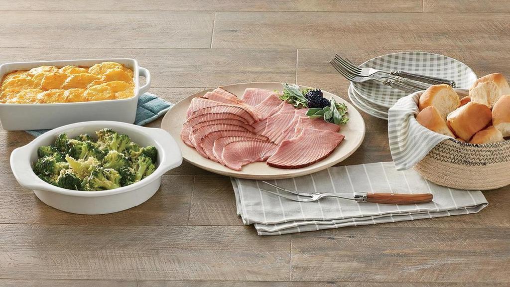 1 Lb Ham By-The-Slice Supper W/Take & Bake Cheesy Potatoes Au Gratin, Green Bean Casserole & Rolls  · Serve our By-The-Slice Supper any night of the week! This meal features:. -1 lb of Bone-in Honey Baked Ham Slices. Our slices are ready to serve, carved right from our signature bone-in ham.. -Cheesy Potatoes Au Gratin and Green Bean Casserole Heat & Serve side dish (simply bake or microwave). -One package of King's Hawaiian rolls. -Serves 2-4
