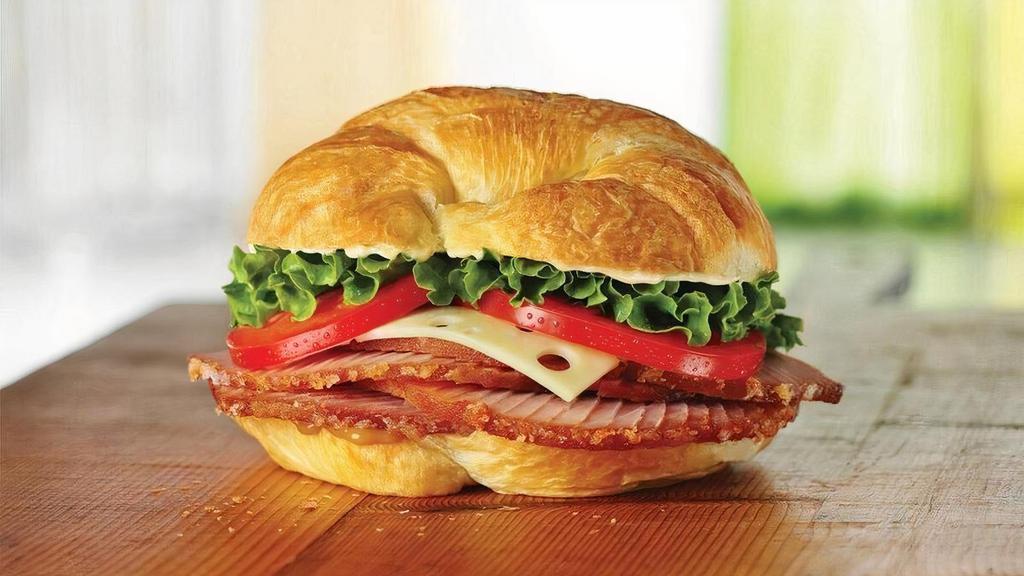 Ham Classic · Honey Baked Ham topped with Swiss cheese, lettuce, tomato, Duke’s® mayonnaise, and hickory honey mustard on a flaky croissant. 630 cal.