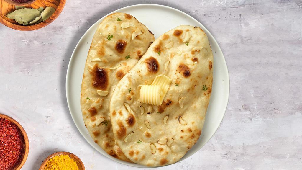 Garlic Naan Nights · Freshly baked bread in a clay oven garnished with garlic and butter.