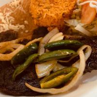Carne Asada · Tender ribeye served with grilled onions, jalapeños, rice, beans, guacamole salad, and torti...