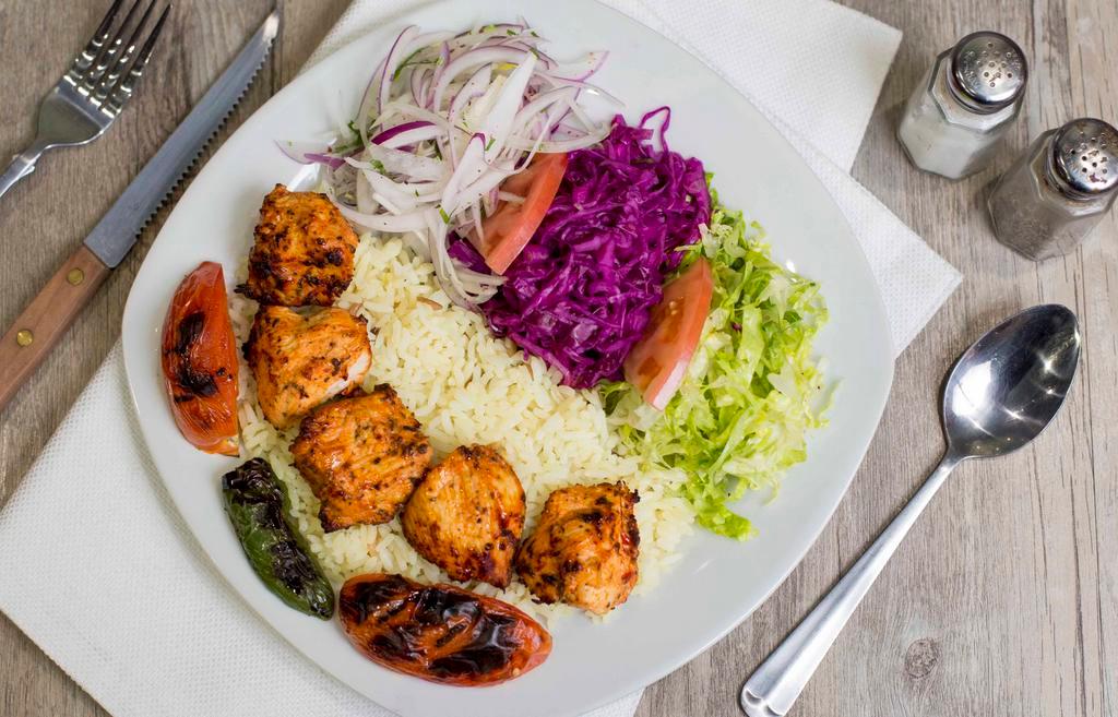Chicken Shish Kebab · Marinated chunks of chicken char-grilled to perfection. Served with rice mixed salad, marinated red cabbage, red and white sauce and bread.