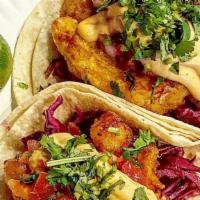 Fish Tacos (Two) · Two soft corn tortillas, doubled up, and filled with beer-batted fried catfish, pickled cabb...