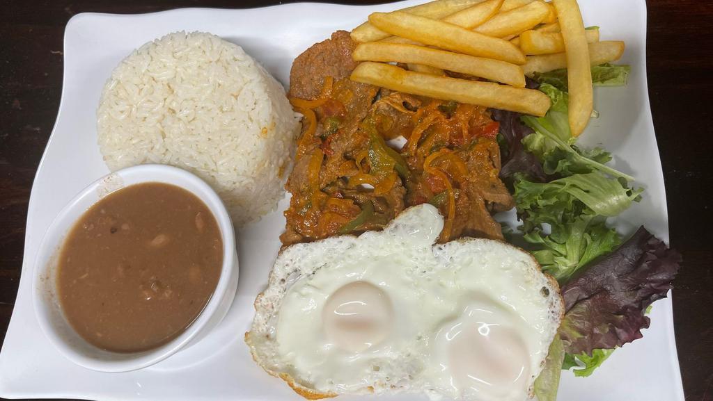 Ecuadorian Churrasco · Beef cooked with onions, tomato, peppers, and two eggs.